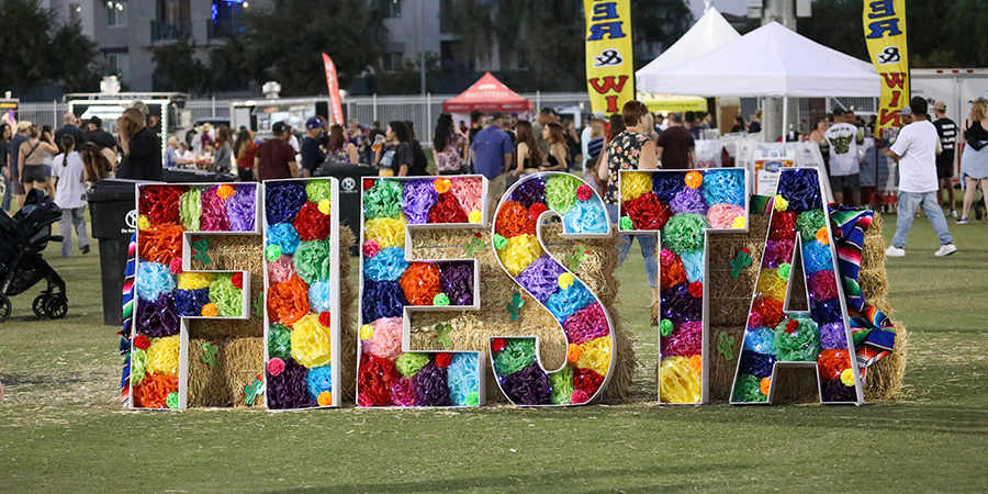 Large metal letters filled with paper flowers spell out the word fiesta