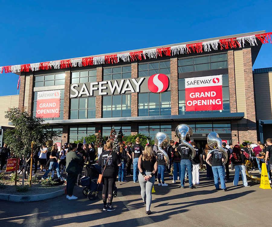 A group of people gathered outside of the new Safeway building