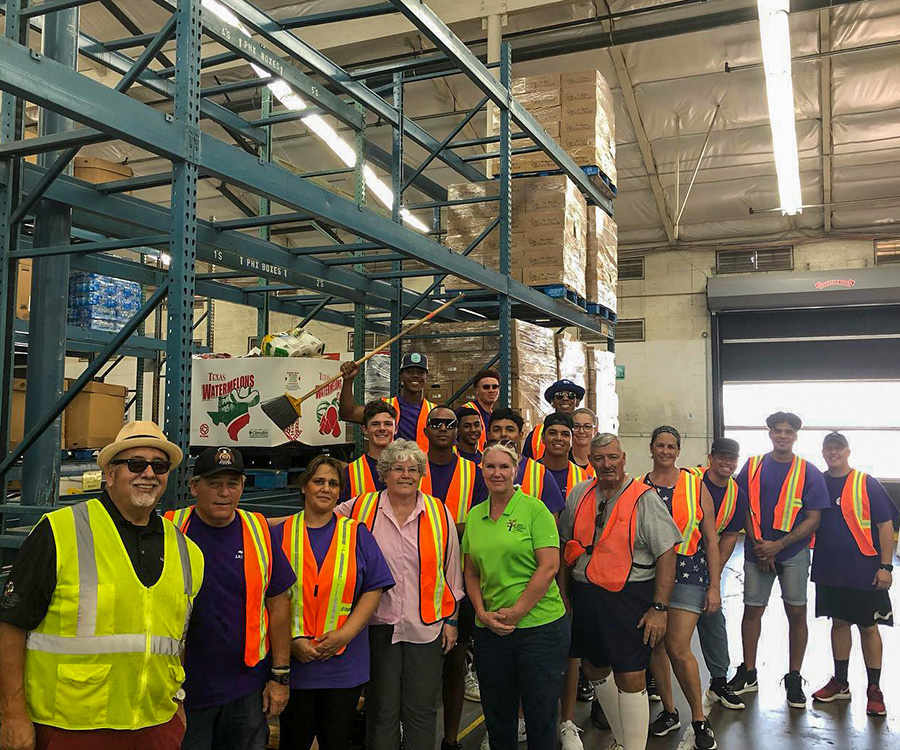 a group of people wearing safety vests inside a warehouse