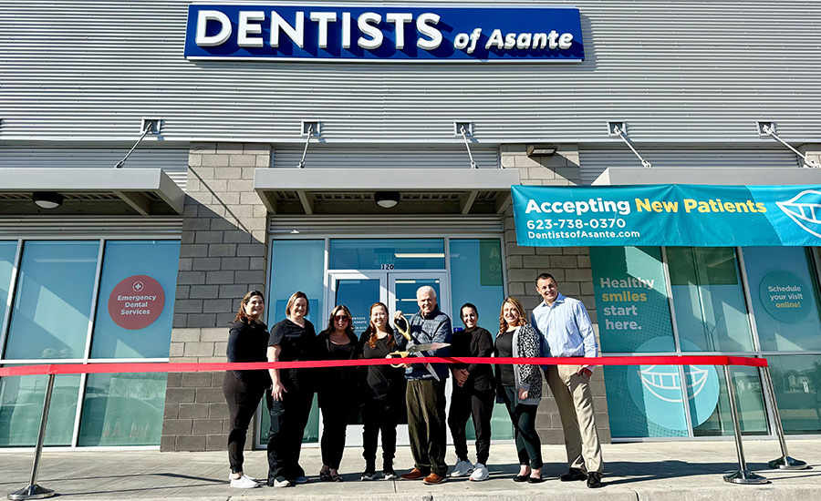 Staff from Dentists of Asante join Mayor Hall who cuts a red ribbon in front of the new business.
