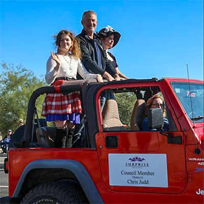 Councilmember Judd and his daughters ride in a red jeep in the Veterans Day Parade
