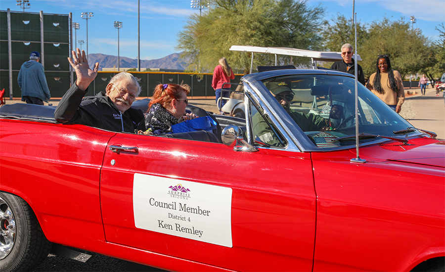 Councilman Remley waves from a red car