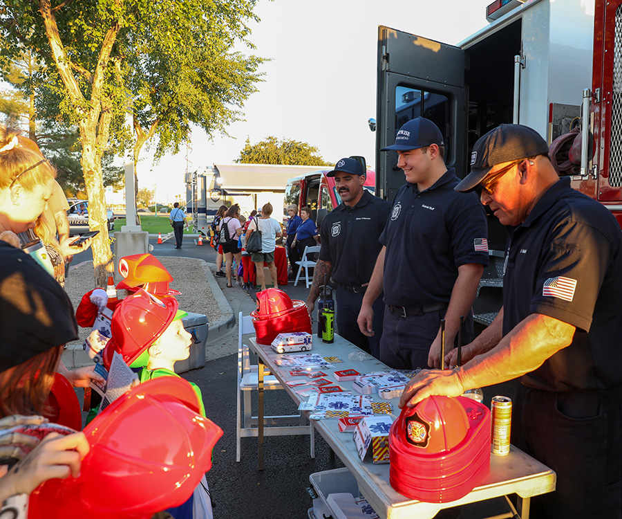 Members of Surprise Fire Department give stickers and plastic hats to children.